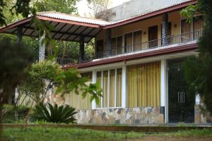 una casa con un balcón en el lateral. en Green Lake View Yala Resort, en Tissamaharama