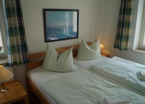two beds with white sheets and pillows in a room at Lichtdurchflutete Fewo mit 2 Balkonen, strandnah, mit Parkplatz in Kühlungsborn