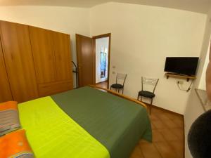 a bedroom with a green bed and two chairs at Alloggio Turistico La Balocca in Montefiascone