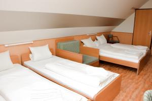 クーセグにあるCsikar Csárda és Panzióのベッド2台と椅子が備わる客室です。