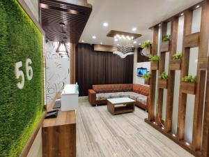 een woonkamer met een bank en een groene muur bij Flexi Hospitality-Hotel 56 -अमृतसर का सबसे सस्ता होटल in Amritsar