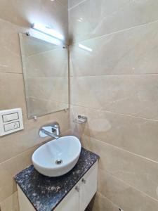 een badkamer met een witte wastafel en een spiegel bij Flexi Hospitality-Hotel 56 -अमृतसर का सबसे सस्ता होटल in Amritsar