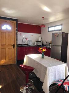 圣地亚哥Hostel Tu Espacio RE - Habitaciones cerca del Aeropuerto的厨房配有一张桌子,上面放着花瓶 更多13张照片