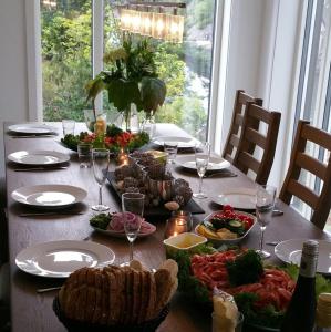 einen Tisch mit Teller mit Speisen und Weingläsern in der Unterkunft Chill Sun in Arendal