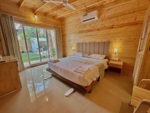 um quarto com uma cama grande num quarto de madeira em The Nine Beach Resort em Canacona