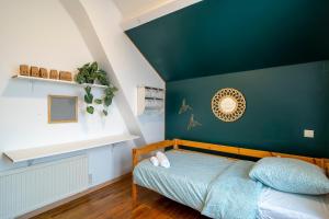 een slaapkamer met een groene accentmuur en een bed bij Gaillarde - Maison pour 8 avec grand jardin in Brive-la-Gaillarde
