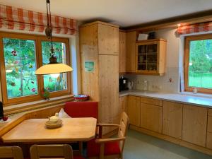 een keuken met een houten tafel en een eetkamer bij Villa Carmen in Bichlbach