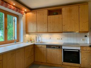 a kitchen with wooden cabinets and a sink at Villa Carmen in Bichlbach