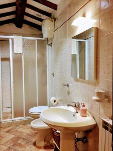 y baño con lavabo, aseo y espejo. en Casa rurale Colleccio - colline di Lucca, en Fibbialla