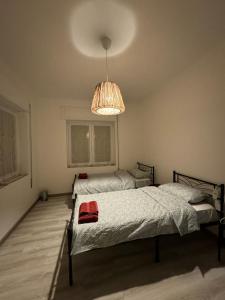 a bedroom with two beds and a chandelier at Lavanda House in Vicenza