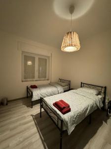 1 dormitorio con 2 camas y lámpara de araña en Lavanda House, en Vicenza