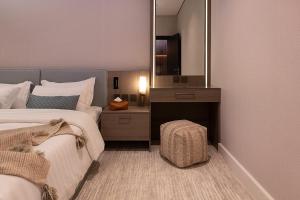 um quarto com uma cama grande e um espelho em Viola Gardens Residence em Riyadh