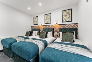 a row of four beds in a room at Classy Designer 4 bed - Parking - Sleeps 13 in Leeds