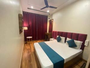 een slaapkamer met een groot bed en een rood gordijn bij Flexi Hospitality-Hotel 56 -अमृतसर का सबसे सस्ता होटल in Amritsar