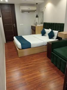 een slaapkamer met een groot bed en een bank bij Flexi Hospitality-Hotel 56 -अमृतसर का सबसे सस्ता होटल in Amritsar