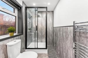 a bathroom with a toilet and a shower at Classy Designer 4 bed - Parking - Sleeps 13 in Leeds