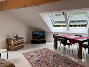 uma sala de estar com uma mesa e cadeiras e uma televisão em DG-Wohnung in Starnberg Nord em Starnberg