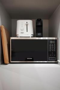 a microwave sitting on top of a shelf with a appliance at Elite Apartments Old Town Ogarna in Gdańsk