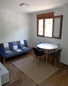 a living room with a couch and a table and chairs at Apartamento Puente Romano in Salamanca