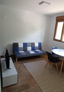 a living room with a blue couch and a table at Apartamento Puente Romano in Salamanca