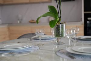 einem Tisch mit Platten und Gläsern und einer Topfpflanze in der Unterkunft Large bright T3 in Saint-Ouen-sur-Seine - Welkeys in Saint-Ouen