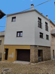 un grand bâtiment blanc avec un garage dans l'établissement Casa Angulosa, à Covilhã