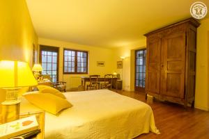 a yellow bedroom with a bed and a wooden cabinet at Gite des Sources d'Arvey in Verrens-Arvey