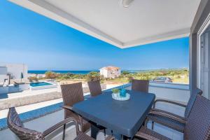 d'une table et de chaises sur un balcon avec vue sur l'océan. dans l'établissement Villa Adria 1, luxury apartment with a pool, à Novalja
