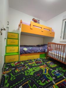 a childs bedroom with a bunk bed and a train rug at Stan na dan Apartman KRISFIL Prnjavor in Prnjavor