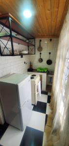 a kitchen with a refrigerator and a stove at Kundayo Serviced Apartments Lodge in Arusha