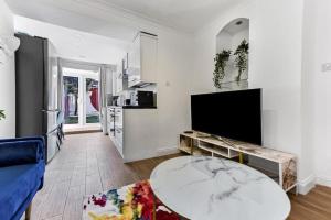 a living room with a table and a tv at Gorgeous Home in Islington in London