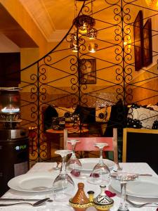 uma mesa com pratos e copos de vinho em Riad Al Wafaa em Marrakech