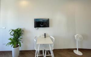 a room with a table and a tv on a wall at T98 Westlake Apartment in Hanoi