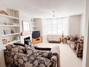 ein Wohnzimmer mit einem Sofa und einem TV in der Unterkunft Home in Hereford in Hereford