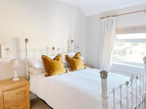 Home in Hereford في هيريفورد: غرفة نوم بسرير ابيض مع مخدات صفراء