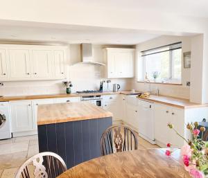 a kitchen with white cabinets and a table with chairs at Home in Hereford in Hereford