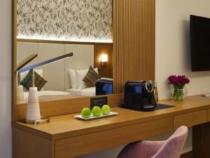 um quarto de hotel com uma mesa e comodidades para preparar café em Qafqaz Riverside Hotel em Gabala