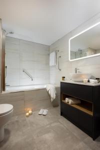 a bathroom with a sink and a toilet and a tub at Fitzpatrick Castle Hotel in Dalkey