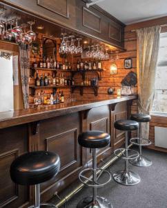 a bar with black stools in a room at Thon Partner Hotel Selbusjøen in Selbu