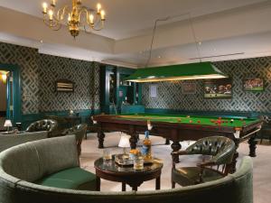 a billiard room with a pool table and chairs at Fitzpatrick Castle Hotel in Dalkey