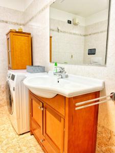 een badkamer met wastafel en wasmachine bij Casa Mazzini in Trento +5 foto's
