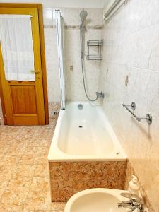 een badkamer met een bad, een toilet en een douche bij Casa Mazzini in Trento
