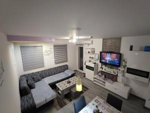 a living room with a couch and a tv at Stan na dan Apartman KRISFIL Prnjavor in Prnjavor