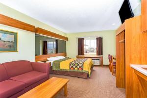a hotel room with a bed and a couch at Super 8 by Wyndham Parker/SE Denver Area in Parker
