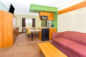 a living room with a couch and a kitchen at Super 8 by Wyndham Parker/SE Denver Area in Parker