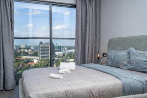a bedroom with a bed with a large window at Escada Studio & 2-bedroom, Rooftop Lounge & Restaurant, Swimming Pool, Gym, Workspace, Wonderiss Properties Westlands Living in Nairobi