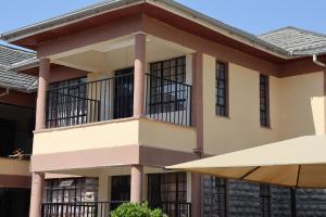 a building with a balcony and an umbrella at AVISHAI HOMES in Kisumu