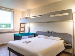 a bedroom with a bed and a bunk bed at ibis budget Roissy CDG Paris Nord 2 in Roissy-en-France