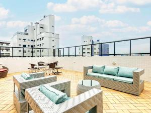 eine Dachterrasse mit Sofas und Tischen auf einem Gebäude in der Unterkunft Mercure Curitiba 7 de Setembro in Curitiba