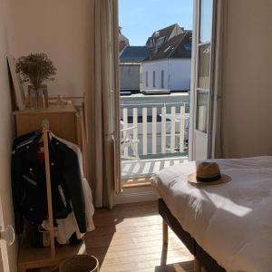 a room with a bed and a balcony with a view at Villa Mon Etoile - Appartements 2 chambres, terrasse, Le Touquet, 200m centre-ville et plage in Le Touquet-Paris-Plage